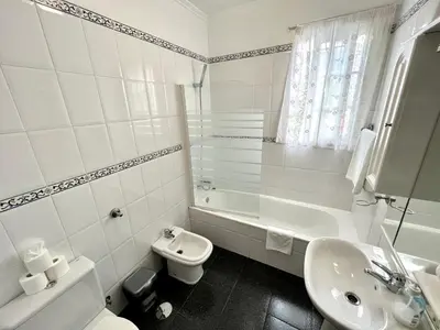 a white bathroom with a toilet and a sink at Classic Tranquil Madeiran 4-Bedroom Villa Funchal in Funchal