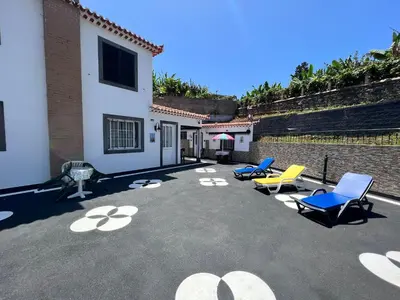 a patio with blue and yellow chairs and a building at Classic Tranquil Madeiran 4-Bedroom Villa Funchal in Funchal