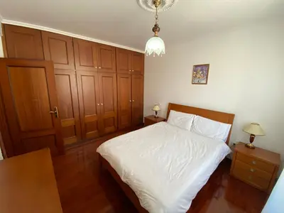 a bedroom with a white bed and wooden cabinets at Classic Tranquil Madeiran 4-Bedroom Villa Funchal in Funchal