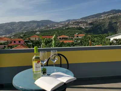 a table with a bottle of wine and two glasses at CASA DOS AVÓS Apartments with Pool in Funchal in Funchal