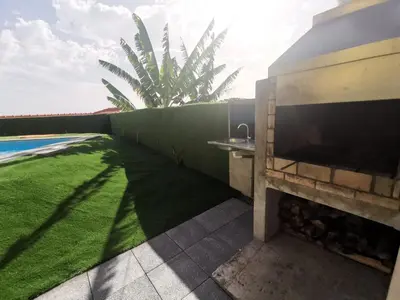 a backyard with a green lawn and a wall with a tv at CASA DOS AVÓS Apartments with Pool in Funchal in Funchal