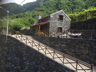 a stone house on a hill with a stone wall at Zef's Cottage in São Vicente