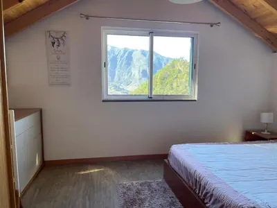 a bedroom with a bed and a large window at Zef's chalet in Senhora do Rosário