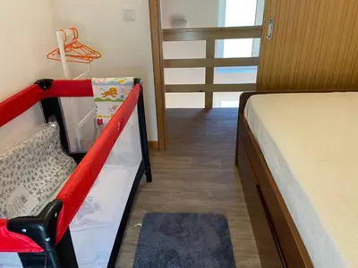 a bedroom with a bed and a red and white bunk bed at Zef's chalet in Senhora do Rosário
