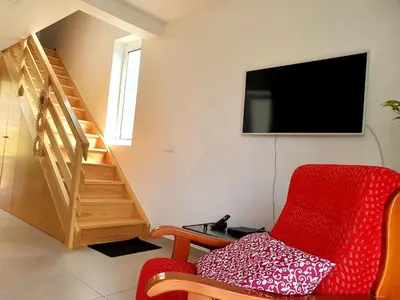 a living room with a red chair and a television at Zef's chalet in Senhora do Rosário