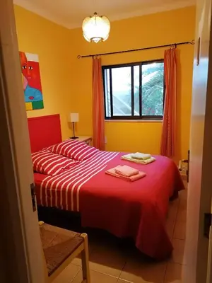 a bedroom with two beds and a window at Casa do Lado in Carrapateira