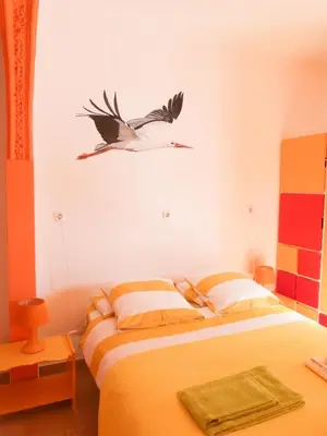 a bird flying above a bed in a bedroom at Casa do Lado in Carrapateira