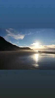 two horses walking on the beach at sunset at Komfortables Town House in traumhafter Lage in Budens