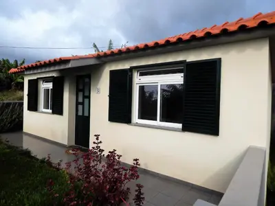 a small house with black shutters on it at Villas Madalena Chalets vista mar cWiFi in Santa Cruz