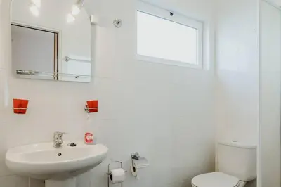 a bathroom with a sink and a toilet and a mirror at City View Gardens in Funchal
