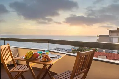 a table and chairs on a balcony with the ocean at Golden Sea Horizon in Funchal