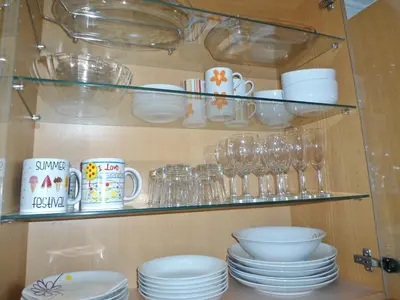 a shelf filled with dishes and cups and plates at Garden's Apartment in Funchal