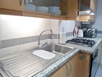 a kitchen with a sink and a stove at Garden's Apartment in Funchal