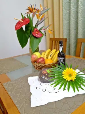 a table with a basket of fruit and a bottle of alcohol at Garden's Apartment in Funchal