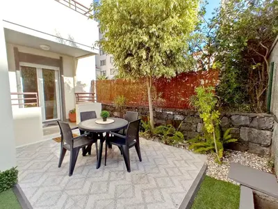 a patio with a table and chairs in a backyard at Garden's Apartment in Funchal