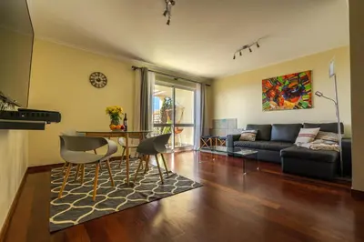 a living room with a couch and a table at Ocean Breeze in Caniço