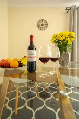a bottle of wine and two glasses on a table at Ocean Breeze in Caniço