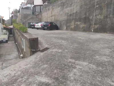 a parking lot with cars parked next to a wall at Casa Alegria in Funchal