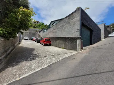 a building with a red car parked next to a street at Casa Alegria in Funchal