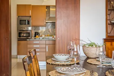 a kitchen with a table with plates and wine glasses at Lajesol in Seixal