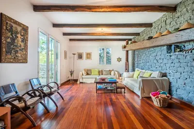 a living room with a couch and a stone wall at Lajesol in Seixal