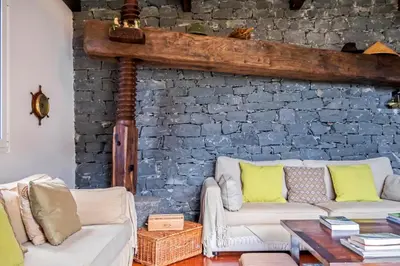 a living room with two white couches and a brick wall at Lajesol in Seixal