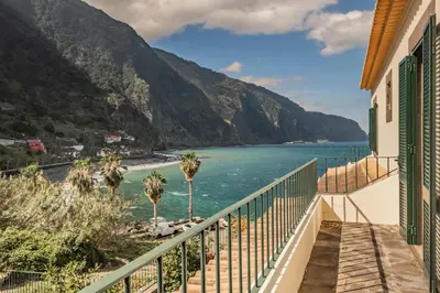 a balcony with a view of the ocean and mountains at Lajesol in Seixal