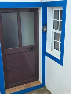 a door to a house with a window at casa Eira Alta in Santa Bárbara