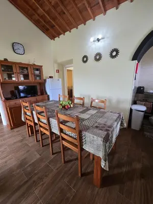 a dining room with a table and chairs and a kitchen at casa Eira Alta in Santa Bárbara