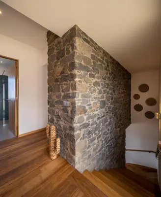 a stone wall in a room with a staircase at Villa Fauna - Nature & Tranquility - Heated pool optional in Prazeres