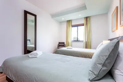 a bedroom with two beds and a mirror at Baia da Luz - Great Light apartment in Luz