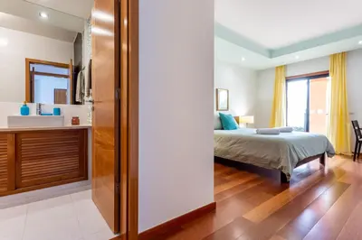 a bedroom with a bed and a bathroom at Baia da Luz - Great Light apartment in Luz