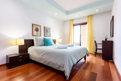 a bedroom with a large bed with blue pillows at Baia da Luz - Great Light apartment in Luz