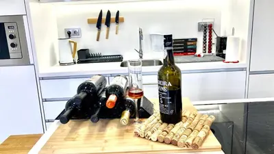 a bottle of wine sitting on a table in a kitchen at Cristalia,Roof terrace in city center, Garage, Netflix 75inch TV in Funchal