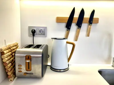 a counter with a toaster and knives on a wall at Cristalia,Roof terrace in city center, Garage, Netflix 75inch TV in Funchal