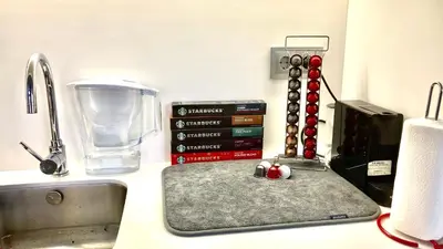 a kitchen counter with a sink and some books at Cristalia,Roof terrace in city center, Garage, Netflix 75inch TV in Funchal
