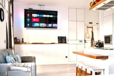 a living room with a couch and a tv on the wall at Cristalia,Roof terrace in city center, Garage, Netflix 75inch TV in Funchal