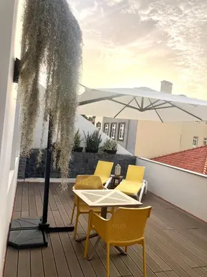 a patio with a table and chairs and an umbrella at Cristalia,Roof terrace in city center, Garage, Netflix 75inch TV in Funchal