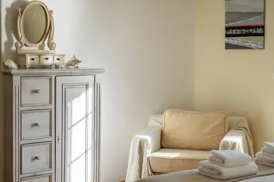 a room with a chair and a mirror and a dresser at Casa das Neves - By Wehost in Funchal