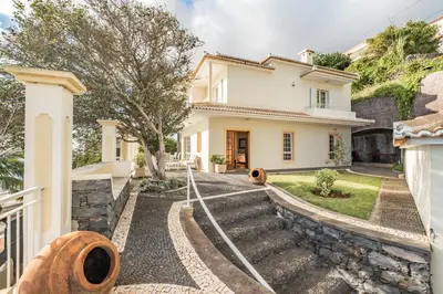 a house with a staircase leading to the front yard at Casa das Neves - By Wehost in Funchal