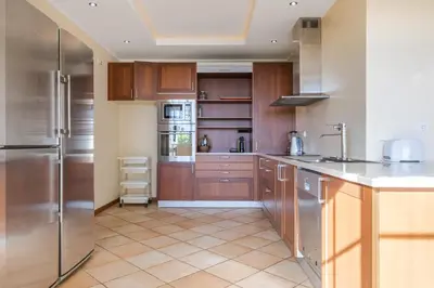 a kitchen with wooden cabinets and stainless steel appliances at Casa das Neves - By Wehost in Funchal