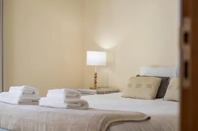 a bed with towels on it with a lamp on it at Casa das Neves - By Wehost in Funchal