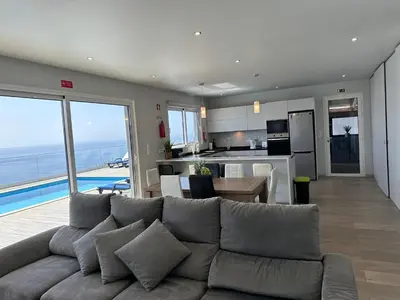 a living room with a couch and a kitchen with a view at Casa Bela Vista in Venda do Atalhinho