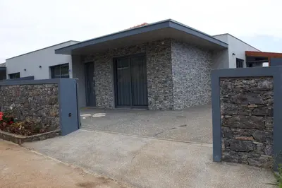 a house with a gate and a stone wall at Casa Bela Vista in Venda do Atalhinho