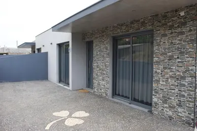 a brick building with glass doors on the side of it at Casa Bela Vista in Venda do Atalhinho