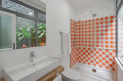 a bathroom with a sink and a toilet and a window at OurMadeira - Villa do Mar IV in Calheta