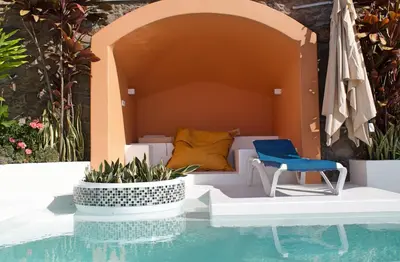 a swimming pool with a chair and a bed at OurMadeira - Villa do Mar IV in Calheta