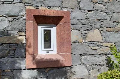 a small window in a stone wall at OurMadeira - Villa do Mar IV in Calheta