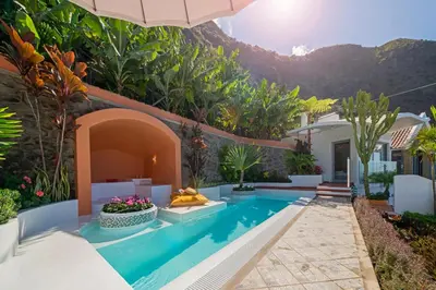 a villa with a swimming pool with a mountain in the background at OurMadeira - Villa do Mar IV in Calheta