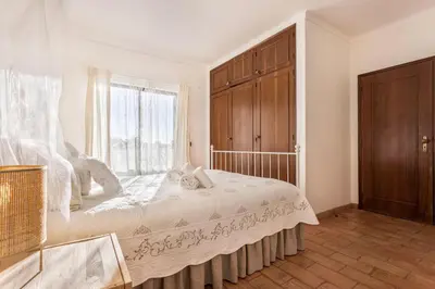 a bedroom with a large bed and a window at Casa da Ermida in Budens